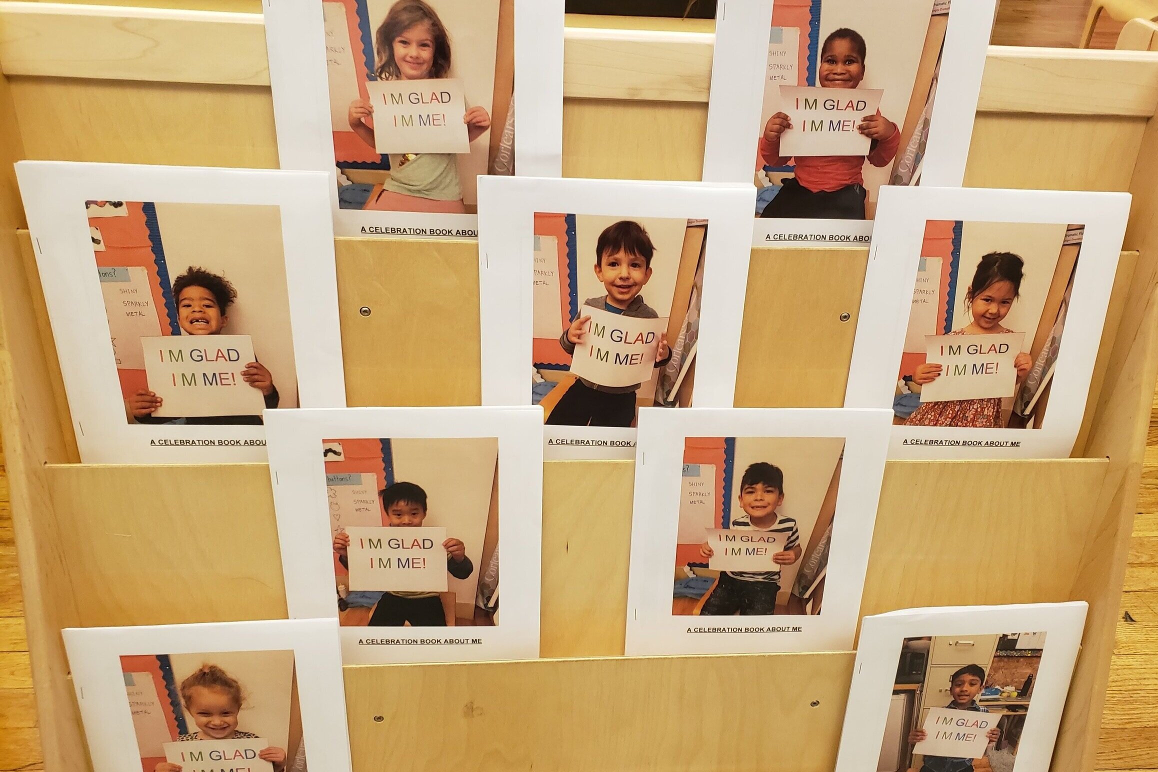 Kindergarten students at Corlears hold up their “I’m Glad I’m Me” identity books.